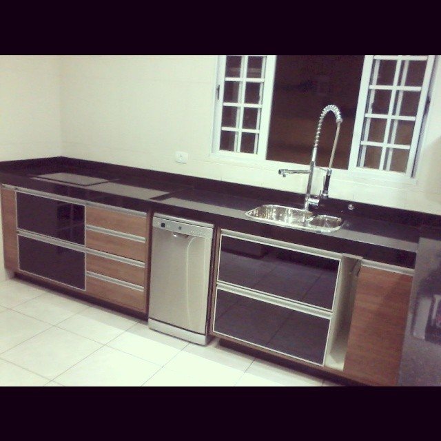 Bancada de cozinha planejada com cuba e armários sob medida